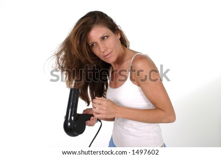 Beautiful brunette woman drying her hair with a blow dryer.