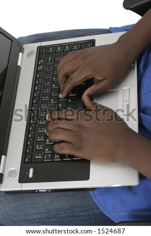 Black African American hands typing on laptop computer keyboard.