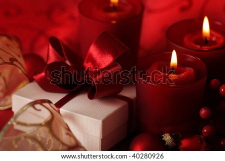 christmas table - candles and gift box on red background