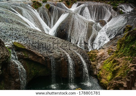The falls shaped like pearls fall into the pit taken in China\'s Guizhou Huangguoshu