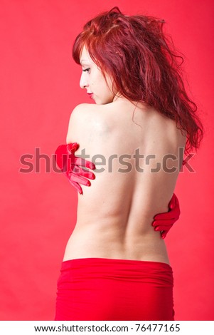 close-up portrait of sexy young red-haired woman on red background