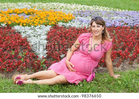 A pregnant woman (9 months) rests in a park