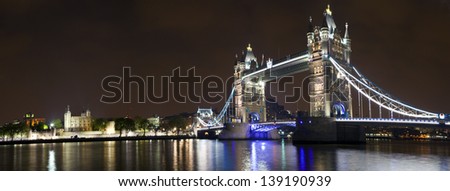 Panoramic view at night, taking in the sights of Tower Bridge and the Tower of London.