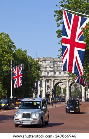LONDON, UK -Â? JULY 9, 2013: London Taxis drive up The Mall with Admiralty Arch in the background.
