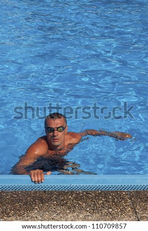 Athletic swimmer posing in a swimming pool