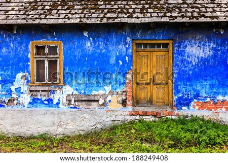 old colorful house front facade with door and window, pained wall and roof