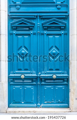 Old fashioned front door entrance, grey facade and blue door, Paris