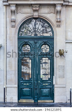 Old fashioned front door entrance, grey facade and green door, Paris