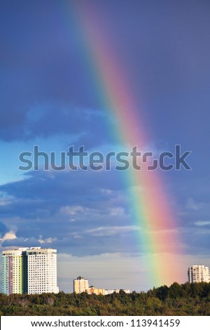 urban house under rainbow in dark blue sky