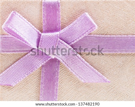 pink bow on shining paper gift box close up