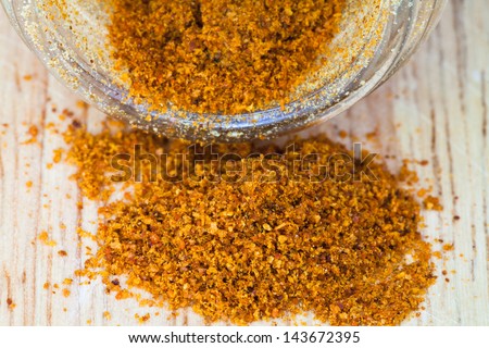 macro view of milled cayenne pepper spilled from glass jar