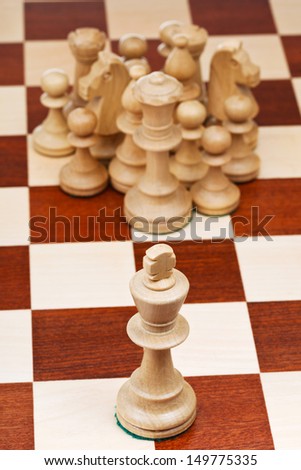 top view of chess figures against the king close up