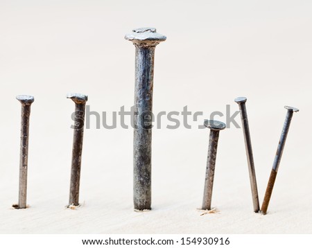 front view of different nails into wooden board