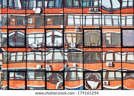 reflection of apartment house in mirror windows of office building