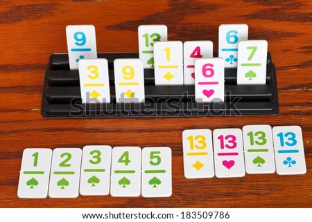 playing in rummy card game on wooden table - run and group of cards
