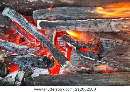 flame over burning wood-burning coals close up
