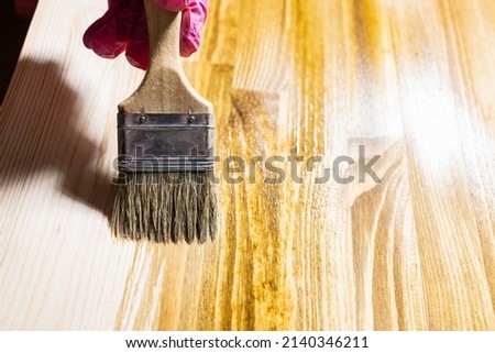 wooden board is covered with wood stain by paint brush close up at home Foto stock © 