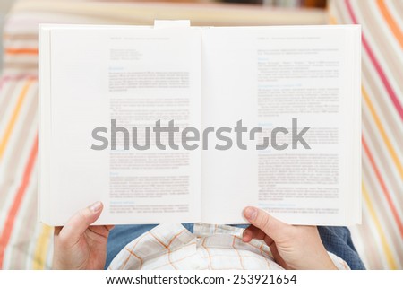 man read book with blurred text in living room