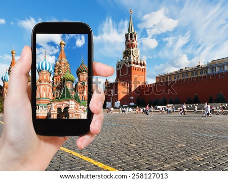 travel concept - tourist taking photo of Red Square in Moscow in summer day on mobile gadget, Russia