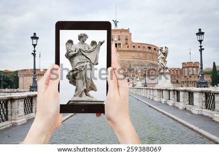 travel concept - tourist taking photo of Angel statue on St Angel Bridge on mobile gadget, Rome, Italy