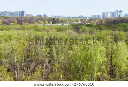 green forest with lake and city in spring day