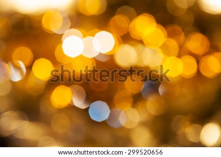 abstract blurred background - yellow and brown shimmering Christmas lights bokeh of electric garlands on Xmas tree