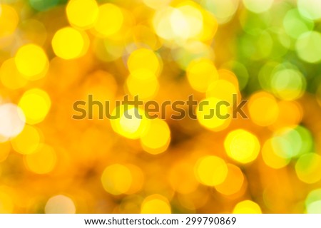 abstract blurred background - yellow and green shimmering bokeh Christmas lights of electric garlands on Xmas tree