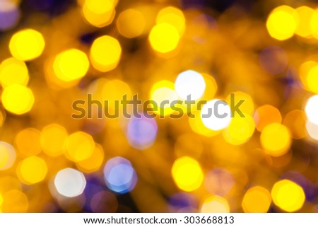abstract blurred background - blue and yellow shimmering Christmas lights bokeh of electric garlands on Xmas tree