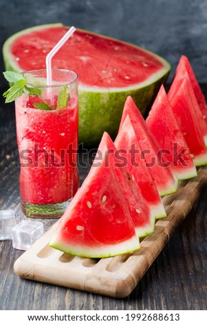 Fresh watermelon juice with ice in a glass. Slices of watermelon on the table.Fresh watermelon juice with ice in a glass. Slices of watermelon on the table.
