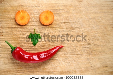 Face made of vegetables on wooden background