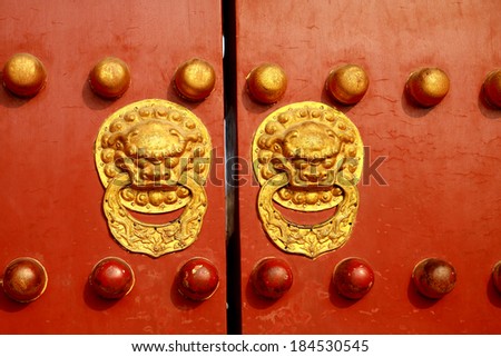 Chinese traditional designs(Qing dynasty style) red door with dragon head knob in Temple of Heaven,city Beijing, China. It reflects imperial power and the august presence.