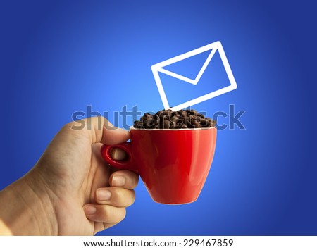 e-mail and coffee beans in red cup on Blue background