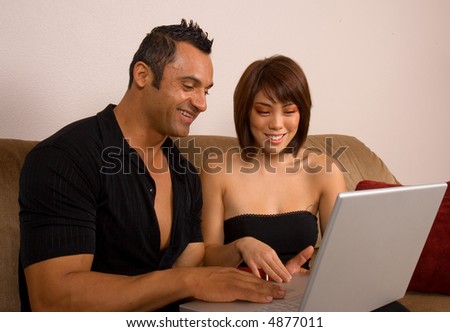 Beautiful couple enjoying their new laptop computer together