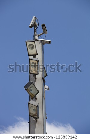 Surveillance cameras and floodlights on top of the pole