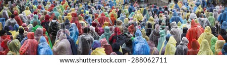 Crowd in colorful plastic raincoat ponchos
