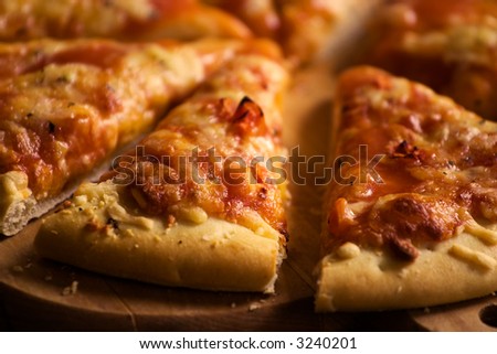 Pieces of cheese pizza on wooden plate
