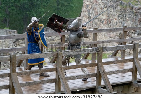CESIS, LATVIA, June 7: Knight sword fight on wooden bridge during  the medieval festival Livonia. 1378. Held in Cesis, Latvia on June 7, 2009