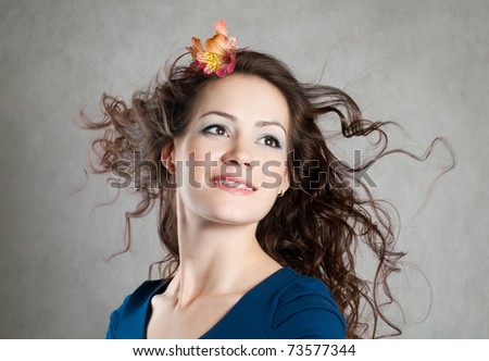 Beautiful young smiling woman with fly-away hair, blowing hair