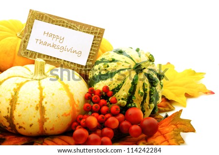 Happy Thanksgiving tag among a group of pumpkins, gourds and autumn leaves
