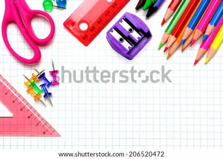 Colorful school supplies corner border over graphing paper