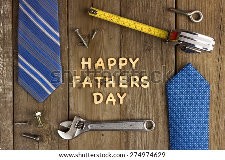 Happy Fathers Day wooden letters on a rustic wood background with tools and ties frame