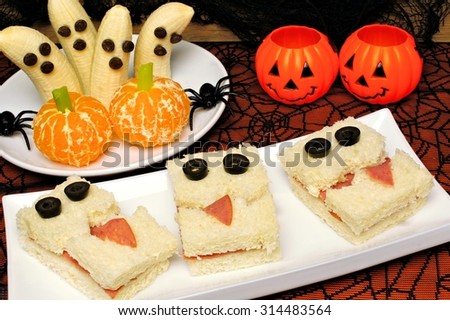 Healthy Halloween treats, monster sandwiches, banana ghosts and orange pumpkins with holiday decor