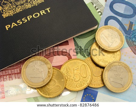 Travel spending - Close up of Euro coins and bills surrounding a passport