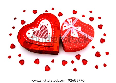 Two Valentines Day heart-shaped gift boxes with gems and confetti over white
