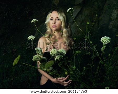 Twilight portrait of beautiful young lady with bouquet of flowers