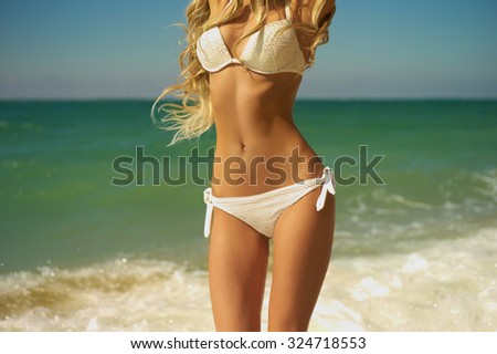 Beautiful slender blonde at the sea. Summer travel photos