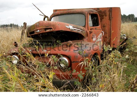 old farm truck abandoned in field