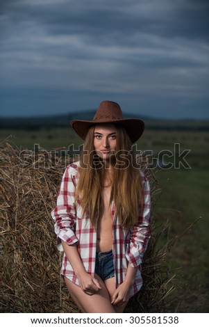 Happy woman in the field in cowboy style