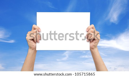 Hands holding paper over the sky
