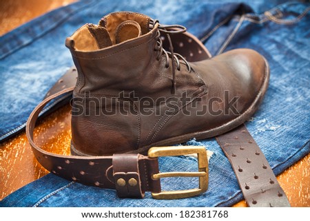 brown leather boots. Fashionable shoes. leather belt with gold buckle. jeans